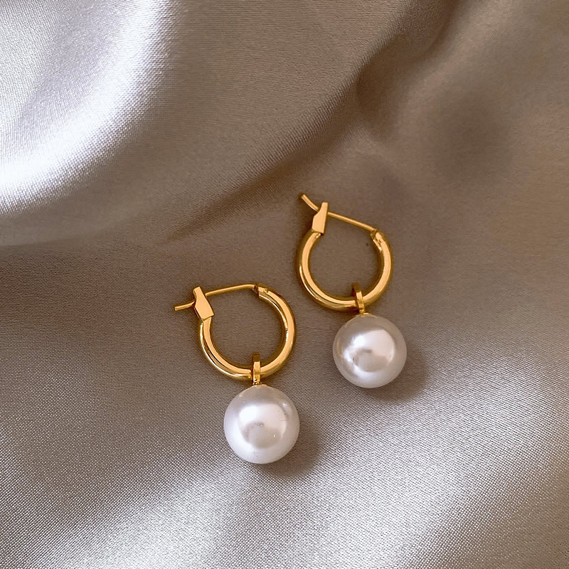 Eleganta örhängen med guldfärgade pärlor
